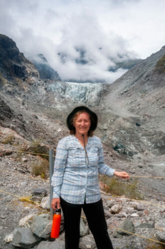 Daniela Constantinescu with Franz Josef Glacier view in the background in New Zealand.
